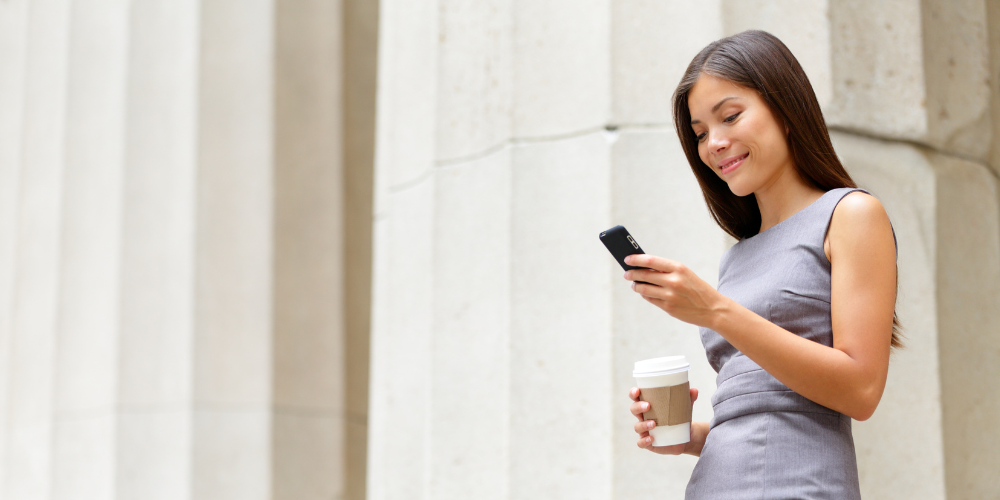 Female lawyer texting in front of court house.