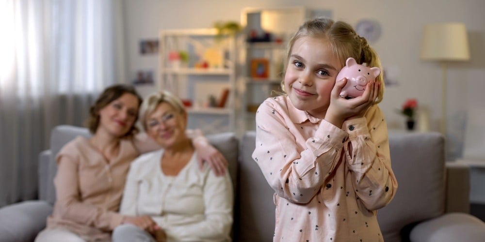 Multi-generations. Youngest girl with piggy bank. 